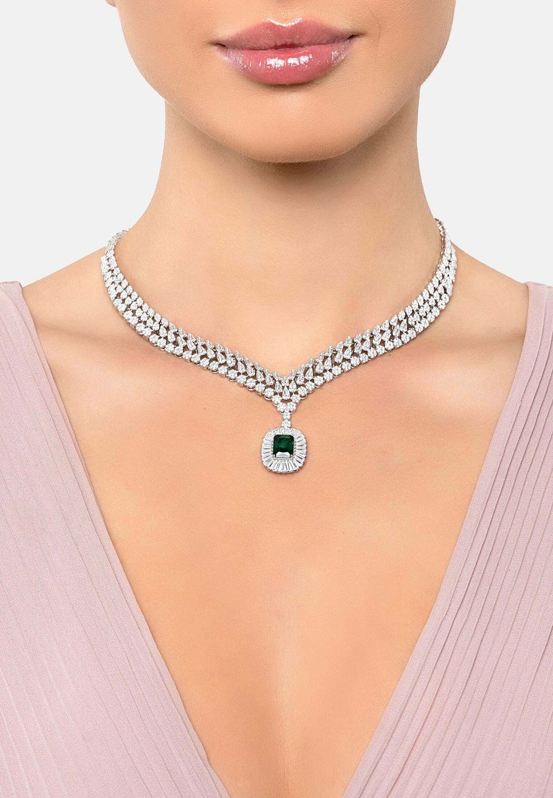 Silver-tone necklace featuring a dual-row design with sparkling clear stones and a central green gemstone accent.