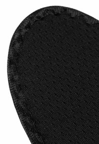 Black fabric in a textured pattern, with a smooth edge and visible stitching, featuring a heart-shaped design.