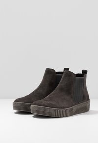 Bottes cheville en daim gris avec panneaux latéraux élastiques, semelle texturée et bout arrondi. Semelle extérieure en caoutchouc striée pour une meilleure adhérence.