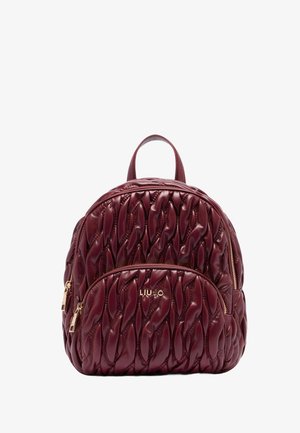 Quilted burgundy leather backpack with front zip pocket, gold-tone zippers, and top carrying handle.