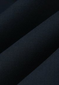 Granatowa tkanina o teksturze z ryflowanym wzorem, ukazująca trzy złożone warstwy z miękkimi, splecionymi włóknami. Gładka powierzchnia, jednolity kolor.