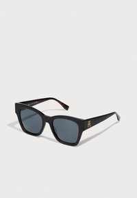Ochelari de soare cu ramă în stil tartă, cu lentile întunecate, formă pătrată și logo auriu pe lateral. Material plastic neted, design minimalist.