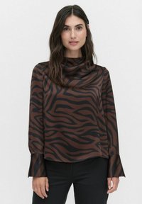 Blouse en soie marron avec des rayures zèbre en marron foncé et noir. Possède un col montant et des manches longues évasées. Texture lisse.