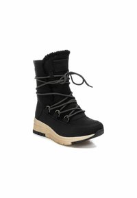 Botas negras hasta el tobillo con un suave cuello forrado de pelo, cordones resistentes y una suela de goma beige para tracción y soporte.