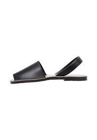 Sanda negra de piel con puntera abierta y tira trasera, suela plana con plantilla texturizada en beige y borde negro cosido.