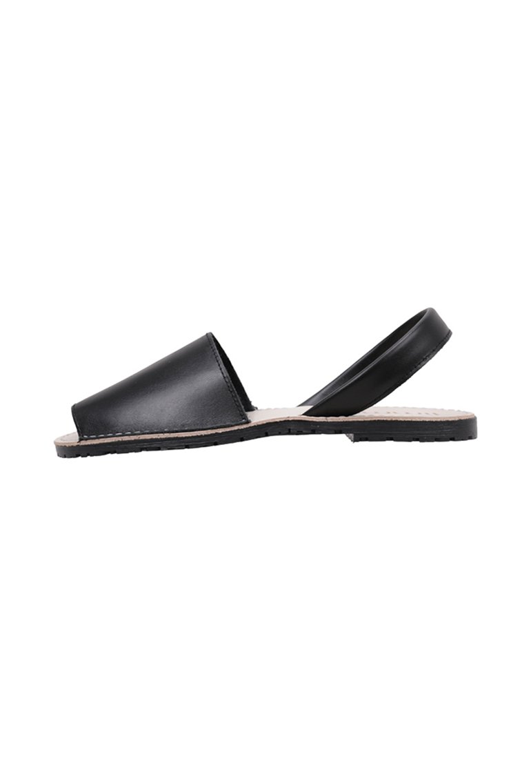 Sanda negra de piel con puntera abierta y tira trasera, suela plana con plantilla texturizada en beige y borde negro cosido.