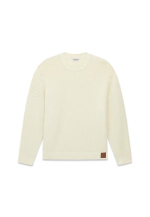 Cremefarbener Strickpullover mit strukturiertem Muster, rundem Ausschnitt, überschnittenen Schultern und einem braunen Lederetikett an der unteren Seite.