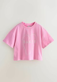Vaaleanpunainen lyhyt t-paita, valmistettu pehmeästä puuvillasta. Siinä on lyhyet hihat ja sydänkuvio, jonka keskellä lukee sana "BAKER".