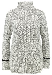 Ljusgrå och vit stickad tröja med hög krage, ribbad textur, lös passform och kontrasterande svarta detaljer vid ärmsluten.