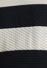 Ύφασμα πλεκτό με υφή, με εναλλασσόμενες φαρδιές οριζόντιες ρίγες σε μαύρο και εκρού χρώμα.