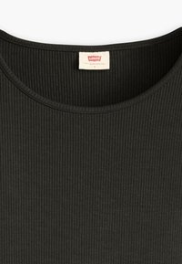 Svart ribbad bomullstopp med rund halsringning. Har en liten vit etikett med röd text som anger märke och storlek.