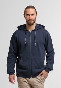 Navy blue zip-up hoodie with a spacious hood, front pockets, and contrast drawstrings. Soft fabric and relaxed fit.