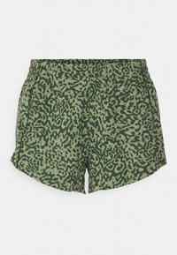 Calções verdes com padrão de estampa de leopardo, apresentando um cós elástico e rachas laterais para maior liberdade de movimento.