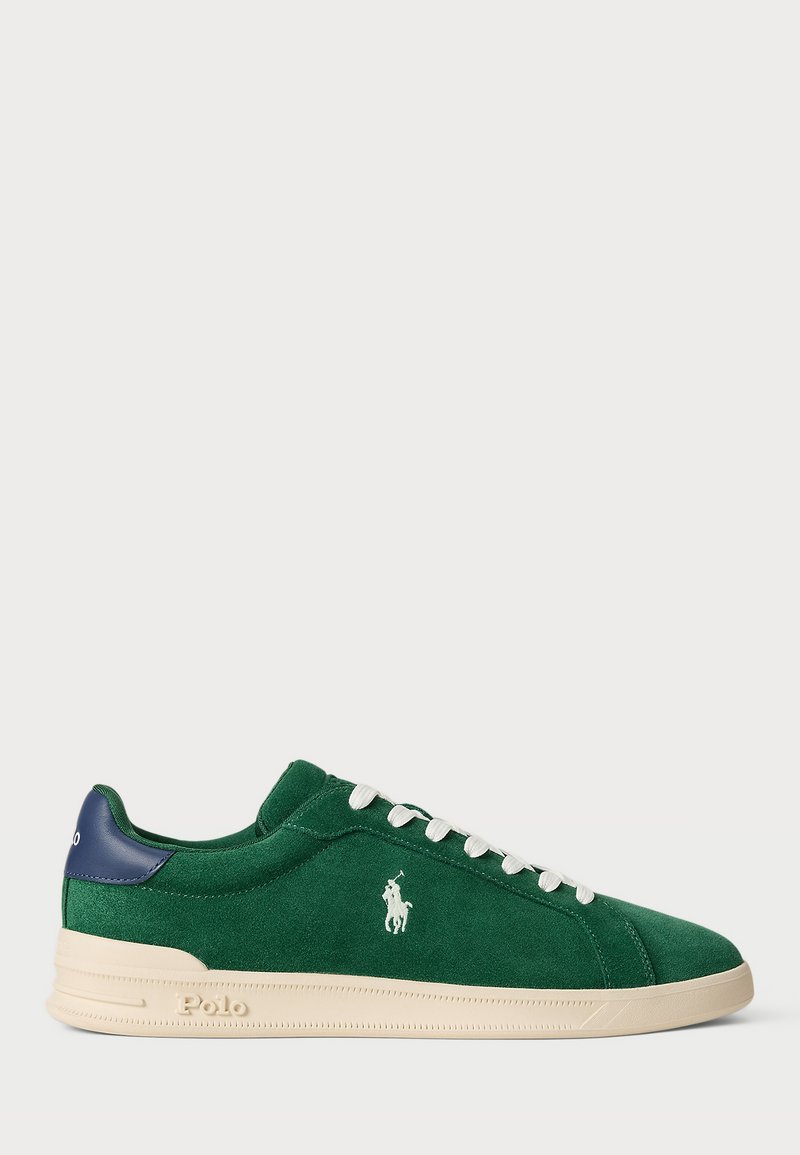 Tenisi verzi din suede cu talpă din cauciuc crem, șireturi albe și un accent albastru la toc. Prezintă un logo alb pe lateral.