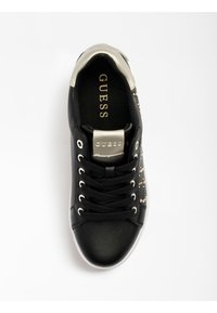 Černé veganské kožené tenisky se lesklým stříbrným akcentem na patě a kovovými cvočky na boku, se černými tkaničkami a bílou podrážkou.