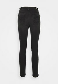 Black skinny jeans featuring a high waist, rear pockets with embroidered designs, and a smooth denim texture.