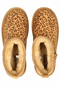 Botines de ante suave con estampado de leopardo y un forro de piel de animal sintético marrón suave, con una suela plana y flexible; cuentan con una cremallera lateral y un borde cosido.