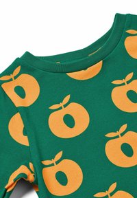 Grünes Stoffhemd mit einem sich wiederholenden orangen kreisförmigen Obstdesign mit Blättern. Rundhalsschnitt und glatte Textur.