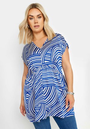 Blouse à motifs bleu et blanc avec un col en V, des manches courtes et une taille froncée. Présente de larges rayures et des designs incurvés.