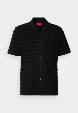 Črna majica s kratkimi rokavi iz teksturiranega blaga, z diskretnim črtastim vzorcem, prsno žepom in blagovno oznako v rdeči barvi.