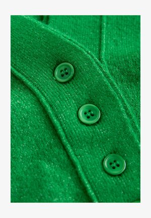 Zaļš adīts kardigans ar teksturētu apdari, aprīkots ar četriem zaļiem apaļiem pogām un ribotu detaļu gar malām.