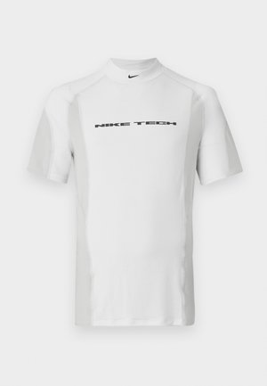 White short-sleeve sports shirt with a high collar, featuring a black "NIKE TECH" logo across the chest and contrasting textured panels.
