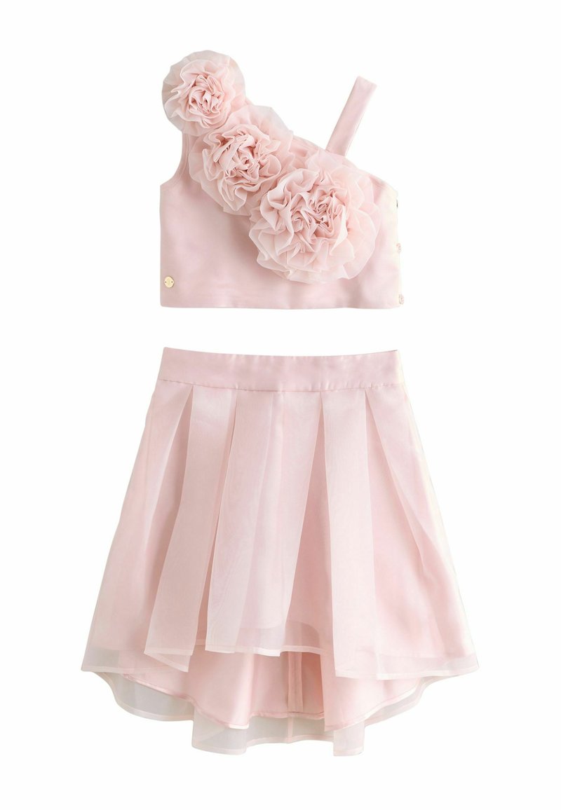 Conjunto rosa de dos piezas que incluye un top sin mangas con tres adornos florales y una falda plisada en capas. Tejido suave con textura delicada.