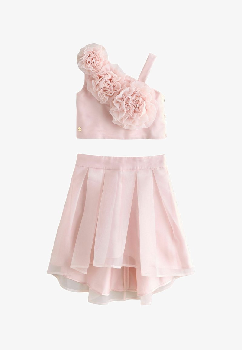 Conjunto rosa de dos piezas que incluye un top sin mangas con tres adornos florales y una falda plisada en capas. Tejido suave con textura delicada.