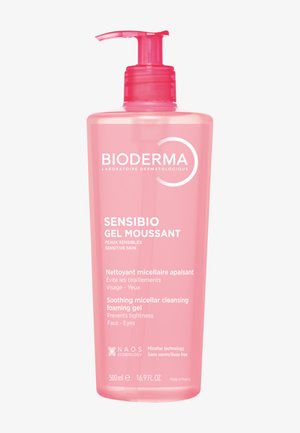 Bioderma Sensibio Gel Moussant dans une bouteille cylindrique transparente rose avec un capuchon à pompe rose. Contient 500 ml, étiqueté pour les peaux sensibles.
