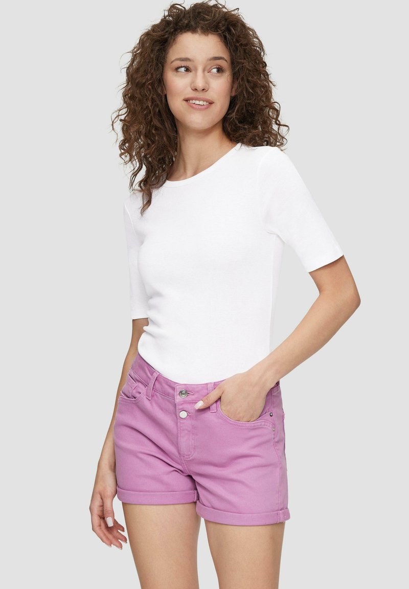 Witte shirt met korte mouwen, gecombineerd met lichtroze denim shorts met opgerolde mouwen, voorzakken en metalen knoopaccenten.