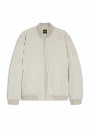 Vaaleanbeige bombarintakki, jossa etuvetoketju, kaksi nepparilla suljettavaa taskua, resorikaulus, -hihansuut ja -helma sekä "BOSS"-logo kaulanauhassa ja vasemmassa hihassa.