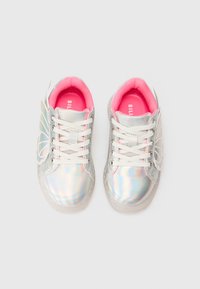 Zapatillas plateadas brillantes de un niño con forro interior rosa y alas en forma de mariposa a los lados, vistas desde arriba.