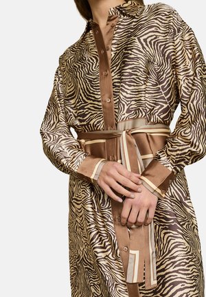 Skjortekjole med zebraprint i brune nuancer, med krave, knaplukning og et bundet bælte med vandrette striber. Glat, blankt stof.