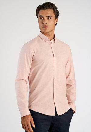 Lichtroze overhemd met knopen, voorzien van een klassieke kraag, lange mouwen, een textuurrijke stof en een afgeronde zoom, gecombineerd met een donkere broek.