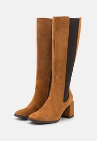 Braune Wildleder-Knielange Stiefel mit quadratischer Zehenform, kontrastierenden schwarzen elastischen Seitenpaneelen und einem klobigen Blockabsatz.