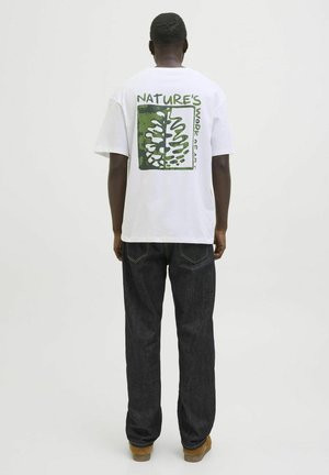 Hvid bomulds t-shirt med et grønt og sort grafisk design på ryggen, der har et bladmønster og teksten: "NATURE'S WORK of ART."