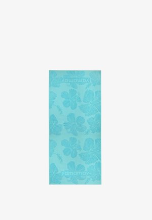 Serviette de plage turquoise avec grands motifs de fleurs d’hibiscus et marquage "yamamay" en haut et en bas.