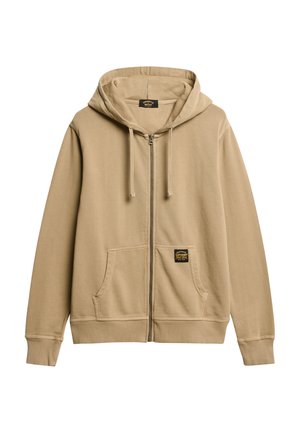 Beige rits-hoodie gemaakt van zachte stof, met een buidelzak aan de voorkant, geribde mouwen en een label op de linkerkant van de zak. Kap met trekkoorden.