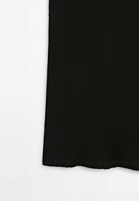 Robe noire côtelée avec une texture verticale, une coupe droite, et un ourlet arrivant au milieu du mollet. Aucune fermeture ou décoration visible.