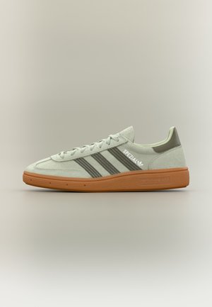 Madala profiiliga Adidas tossud helehallis toonis, tumedate triipudega, kummist tallaga ja küljele paigutatud "Spezial" logoga.