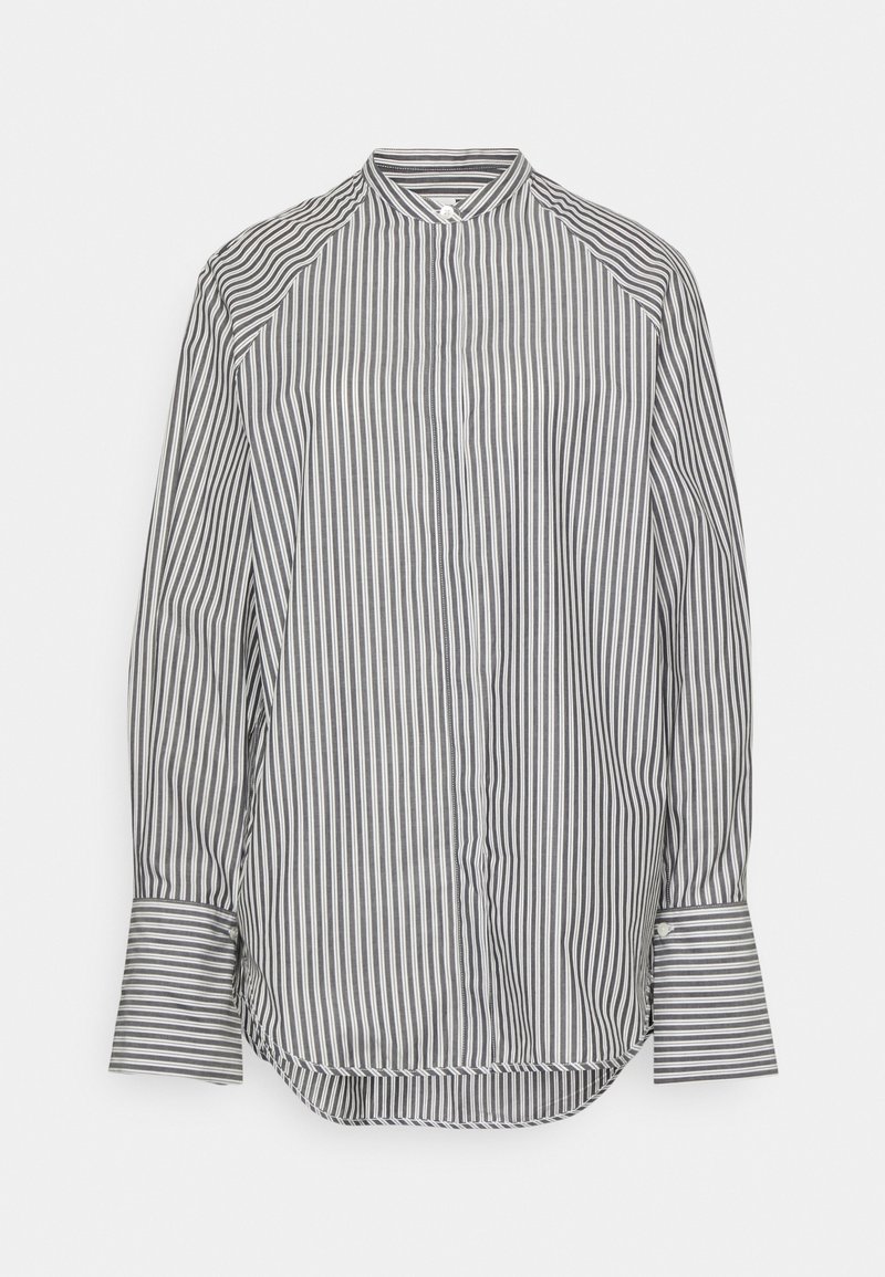 Chemise à manches longues avec des rayures verticales noires et blanches, un col haut et de larges poignets sur fond blanc.