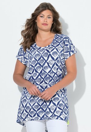 Haut à manches courtes bleu marine et blanc avec un motif de coquillage, encolure ronde et un dos plus long. Le tissu semble doux, avec une coupe décontractée.