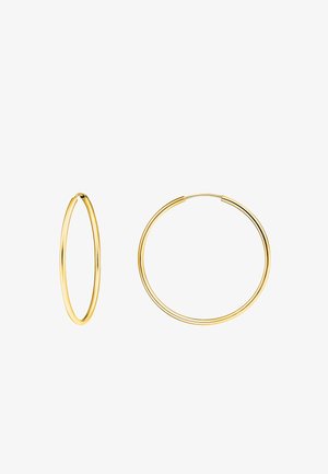 Boucles d'oreilles créoles en or de tailles variées. L'une est fine et allongée, l'autre est plus épaisse avec une surface lisse.