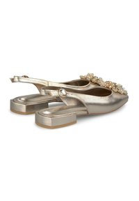 Chaussures slingback métalliques dorées avec un petit talon bloc, ornées de décorations florales et d'une texture lisse.