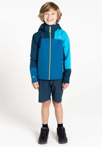 Blaue und türkise Jacke mit einem Reißverschluss vorne und Kapuze, kombiniert mit dunklen Shorts und schwarzen Wanderstiefeln. Glattes Material mit kontrastierenden Akzenten.