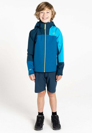 Blaue und türkise Jacke mit einem Reißverschluss vorne und Kapuze, kombiniert mit dunklen Shorts und schwarzen Wanderstiefeln. Glattes Material mit kontrastierenden Akzenten.