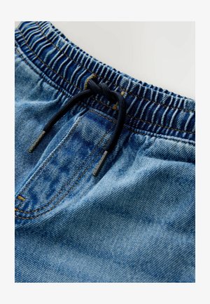 Vaaleansiniset farkkushortsit, joissa on joustava vyötärönauha, tummansininen nyöri ja brodeerattu yksityiskohta. Sisältää etutaskun ja sileän pinnan.