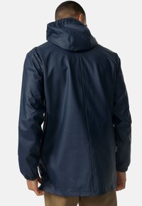Marineblauwe waterdichte jas met een capuchon, elastische manchetten en een rechte achternaad. Gladde, glanzende textuur met een minimalistisch ontwerp.