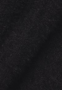 Tela negra con una textura suave y peluda, mostrando una vista en primer plano que resalta sus fibras densas y esponjosas. No se aprecian patrones o acentos distintivos.