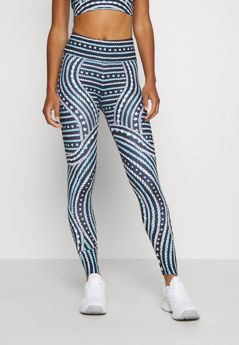 Leggings con base blu navy caratterizzati da un motivo a spirale di strisce blu chiaro, bianche e stelle. Realizzati in materiale flessibile e traspirante.